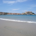The beach in Calvi with the harbour and the citadel in the background