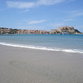 The beach in Calvi with the harbour and the citadel in the background