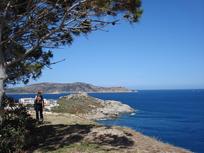 An unknown traveller gazing towards the lighthouse on the horizon
