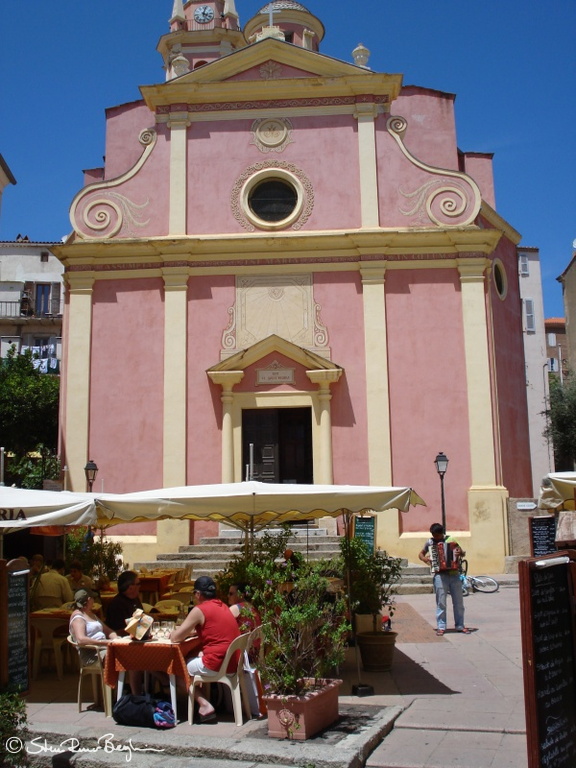 The restaurant-covered square in front of the church in Calvi