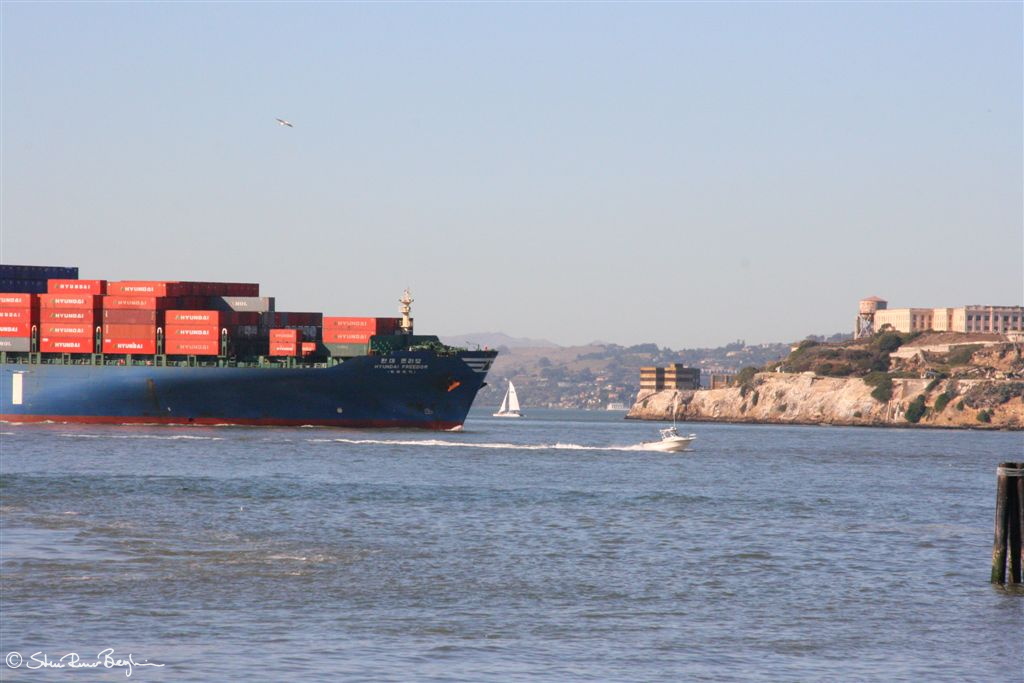 Little flea boat outrunning huge cargo vessel