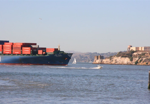 Little flea boat outrunning huge cargo vessel