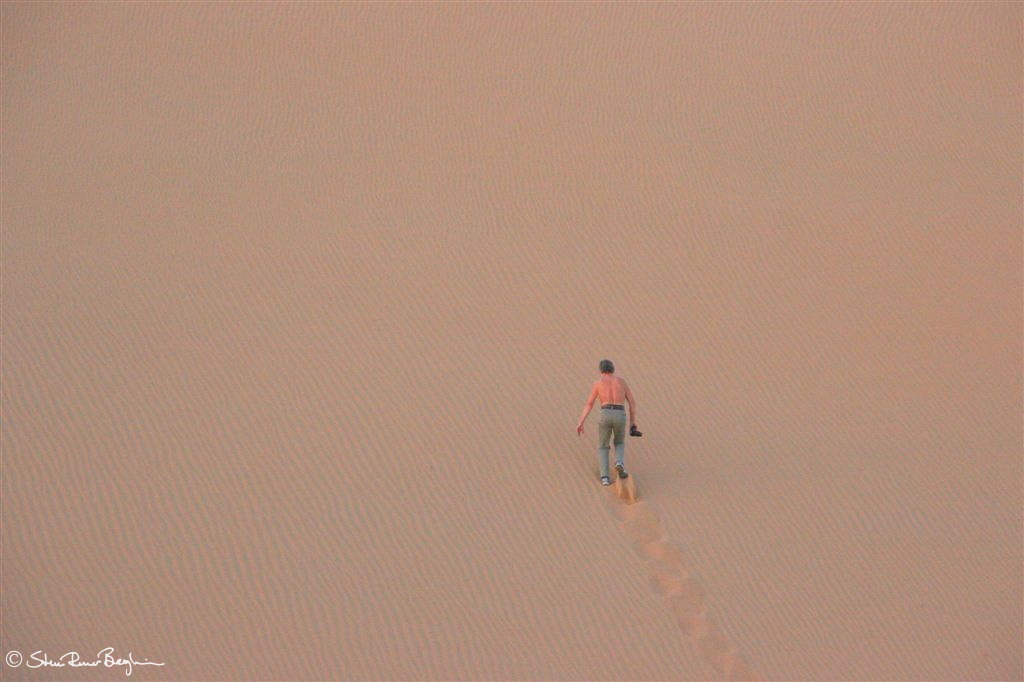 Jens scaling a steep sand dune