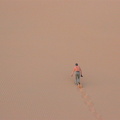 Jens scaling a steep sand dune