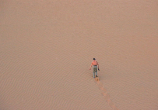 Jens scaling a steep sand dune