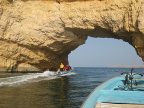 Sailing through portal rock near Barr al Jissah, Oman