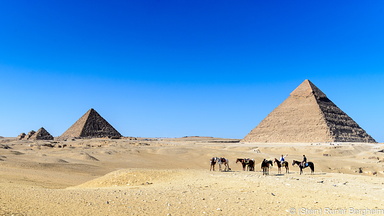 Horses and riders in front of the Pyramids of Giza