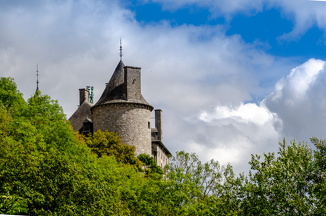The towers of Chateau de Walzin protruding from the forest